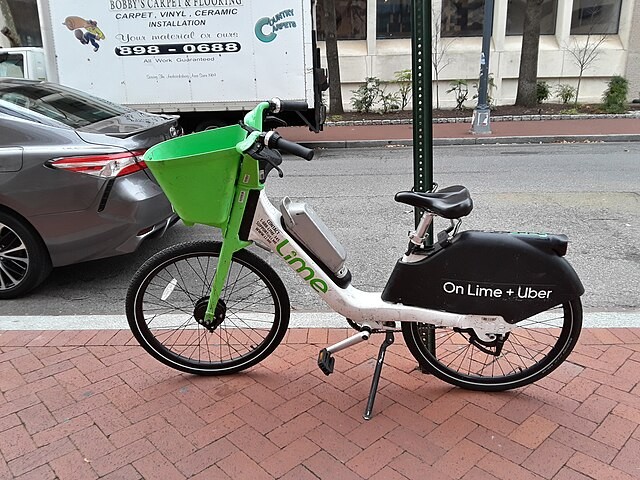 Lime bike parked on the sidewalk